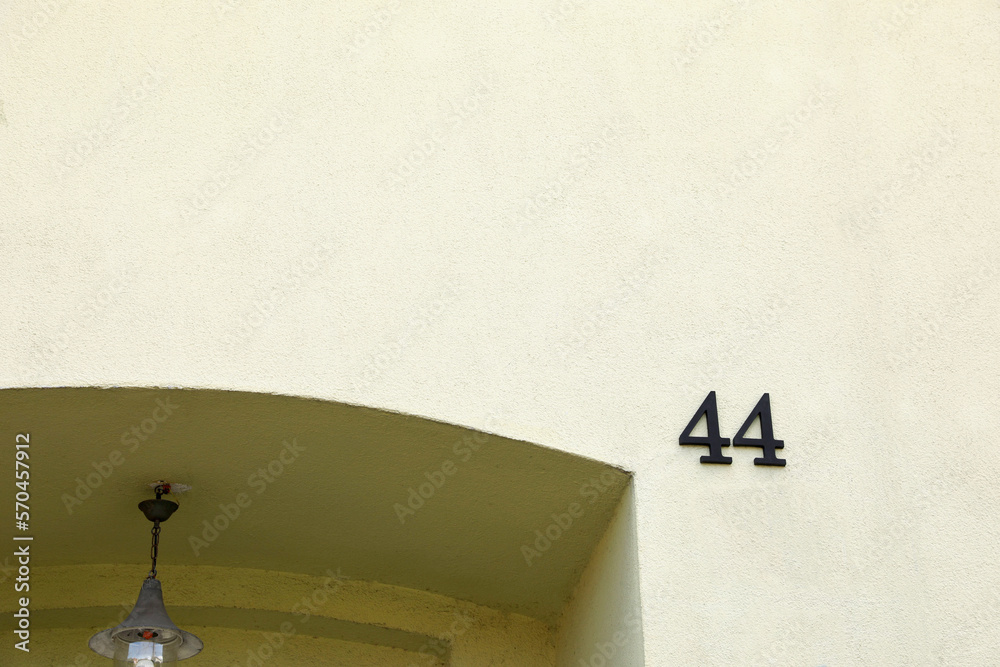 House number 44 on beautiful building outdoors. Space for text