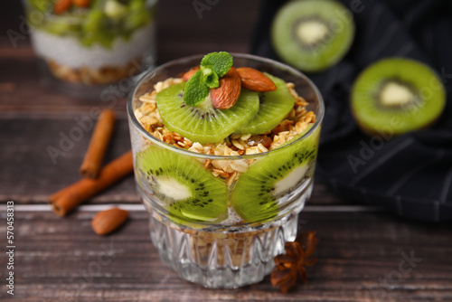 Delicious dessert with kiwi muesli and almonds on wooden table, closeup