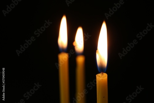 Burning church candles on dark background, closeup. Space for text