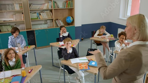 Elementary school class children communicate with the teacher answering question