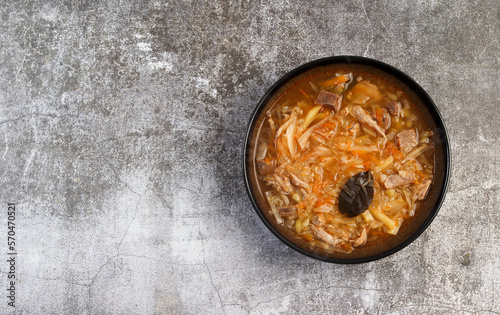 Shchi - traditional russian cabbage soup with beef and sauerkraut in a bowl on a dark background. Top view, flat lay