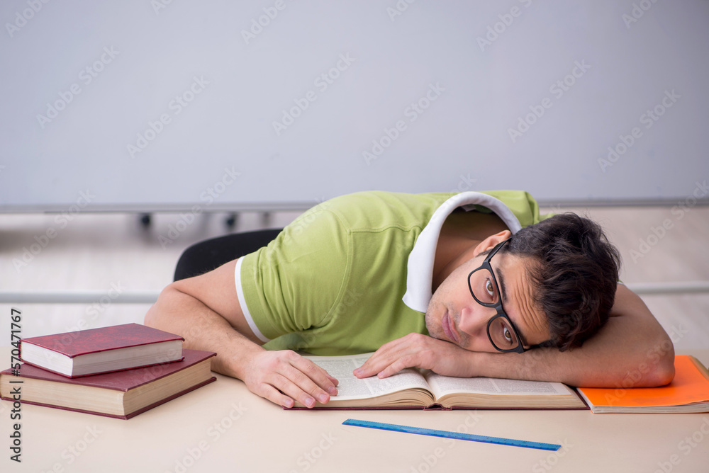 Young male student sitting in the classroom