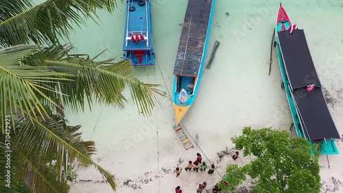 drone camera above the fishing boat that will be leaning. children playing on the beach. photo