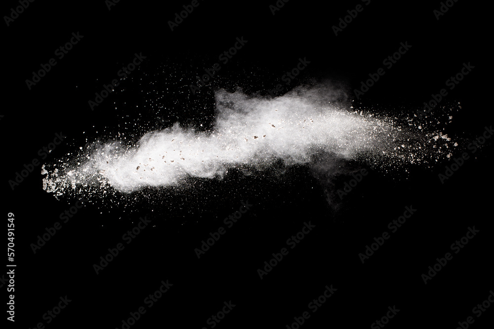 White powder explosion cloud against black background. White dust particles splash. White powder explosion cloud against black background. White dust particles splash.