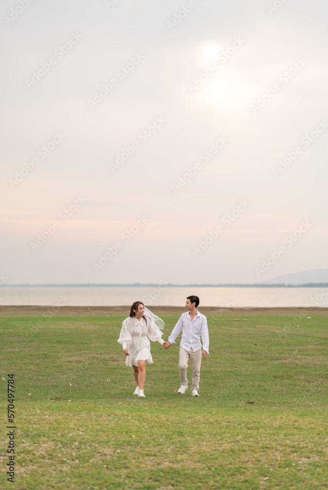 Happy young Asian couple in bride and groom clothing Happy young Asian couple in bride and groom clothing