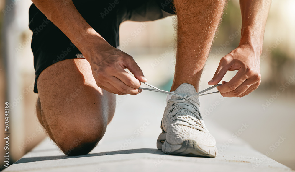 Fitness, shoes and laces with a man runner getting ready for a cardio or endurance workout closeup outdoor. Exercise, running and workout with a male athlete fastening shoelaces while training