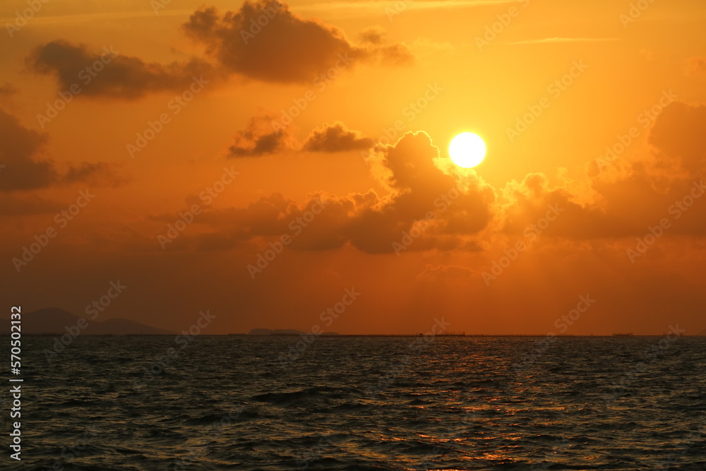Sunset over the sea on the sky with sun shine ray pass orange cloud in the evening
