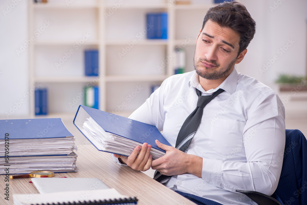 Young male employee and too much work in the office