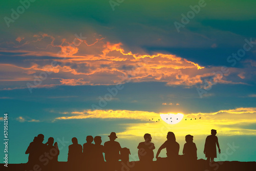 Silhouette people sitting on the floor and sunrise on the colorful sky orange cloud and birds flying