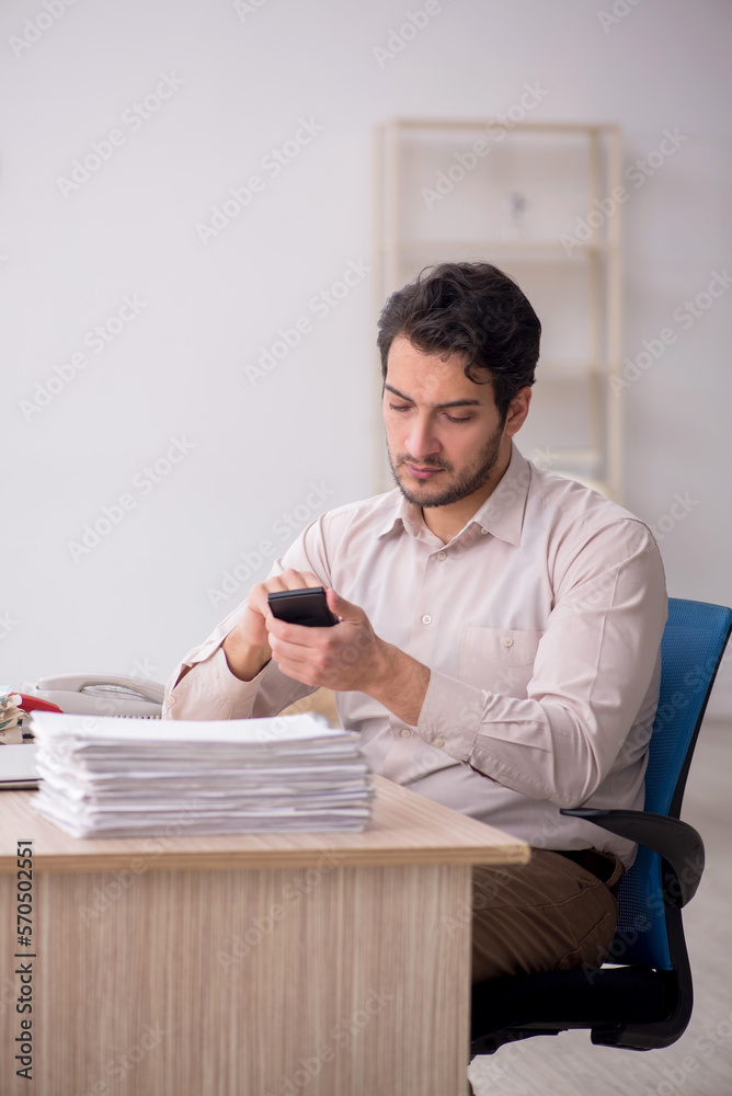 Young male accountant working in the office Young male accountant working in the office