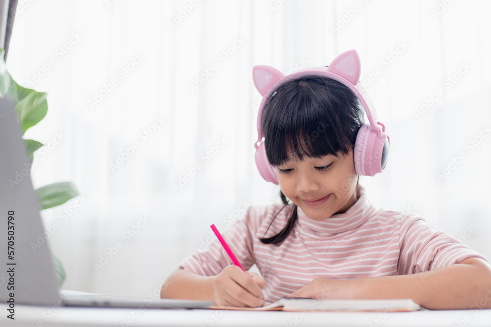 Asian little girl in headphones have video call distant class with teacher using laptop, study online on computer, homeschooling concept Asian little girl in headphones have video call distant class with teacher using laptop, study online on computer, homeschooling concept