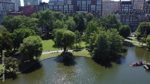 a drone shot of a common park in the boston city in spring season with the lake and trees, people walking, in the region of new england, united states of america