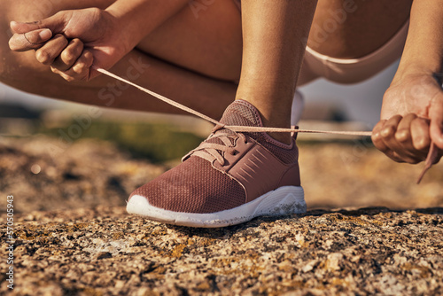 Fitness, hands and tie shoes in nature to start running, workout or training. Sports, wellness and female or woman tying sneaker laces or footwear to get ready for exercising, cardio or jog outdoors.