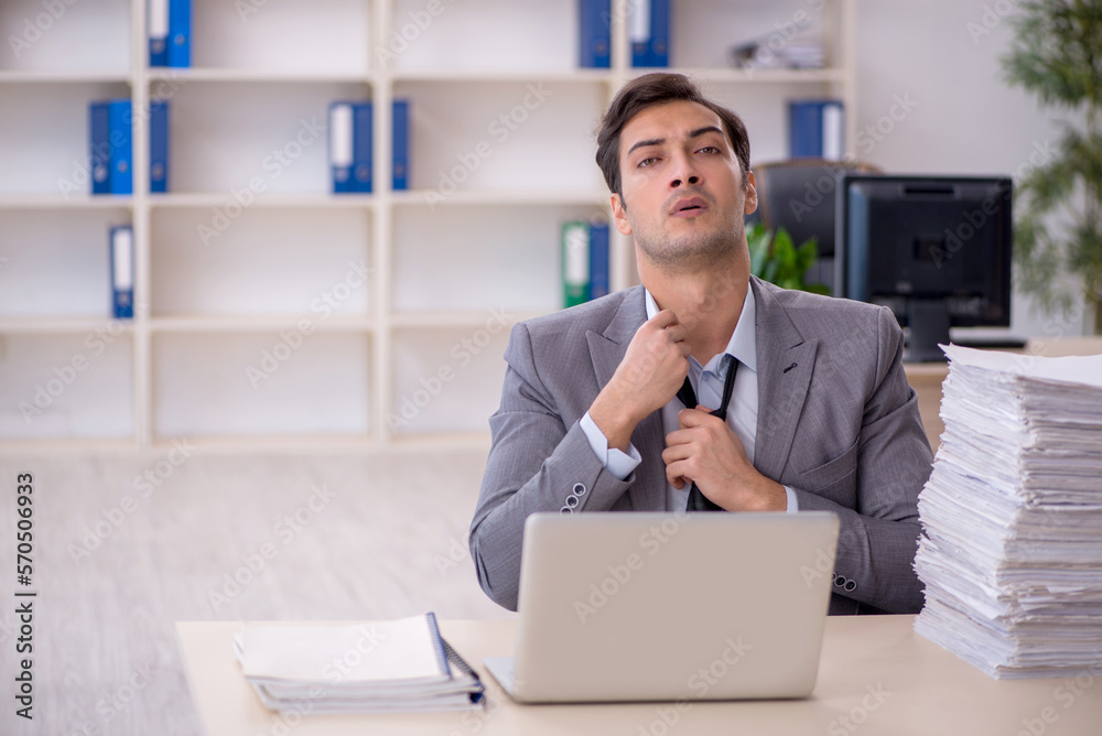 Young male employee and too much work in the office