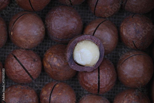 Close-up of macadamia nuts on a white stone, slate or concrete background, the concept of superfoods and healthy nutrition, a picture from above or with a view from above in a vintage color tone