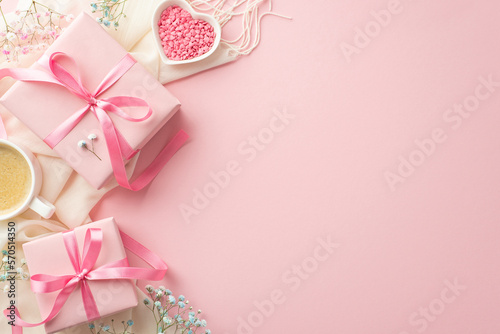 Spring concept. Top view photo of pink present boxes with bows white scarf cup of coffee heart shaped saucer with sprinkles and gypsophila flowers on isolated pastel pink background with empty space © ActionGP