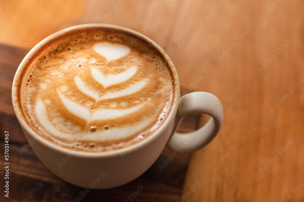 A cup of cappuccino with latte art on a wooden space background. Trendy toning. Minimal composition, Top view, flat lay copy space for your text. A cup of cappuccino with latte art on a wooden space background. Trendy toning. Minimal composition, Top view, flat lay copy space for your text.