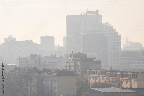 Smog lies over the skyline of Historical architecture of Belgrade city. Poor visibility, smog, caused by air pollution. Rooftop view. Emissions of plants and factories. Belgrade, Serbia 21.12.2022 
