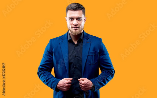 portrait of handsome young smiling man wearing dark shirt and blue suit looking at camera. Black background. Money and business concept. © Vadim