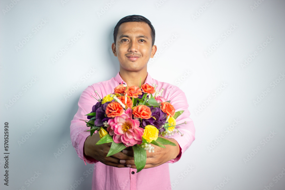 Portrait of Asian young man holding flower wearing pink shirt isolated on white background. Portrait of Asian young man holding flower wearing pink shirt isolated on white background.