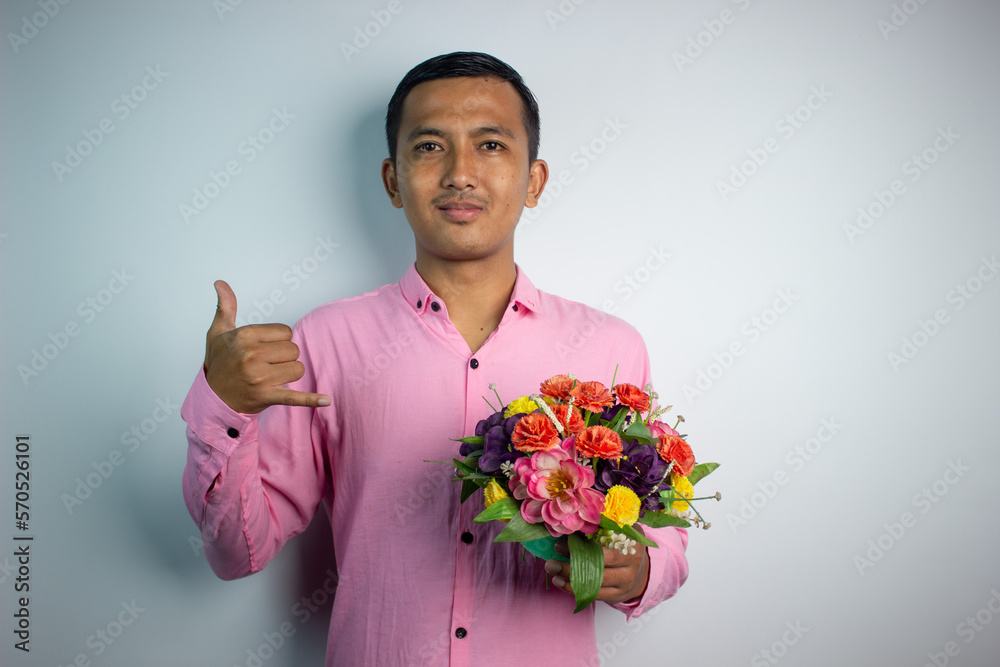 Portrait of Asian young man holding flower wearing pink shirt isolated on white background. Portrait of Asian young man holding flower wearing pink shirt isolated on white background.
