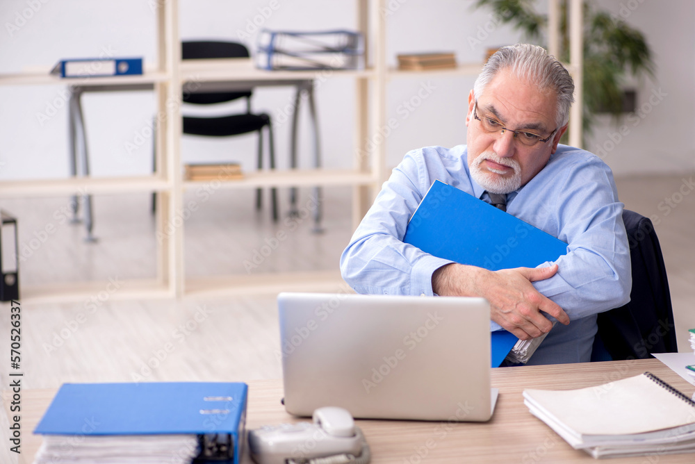Old male employee working in the office Old male employee working in the office