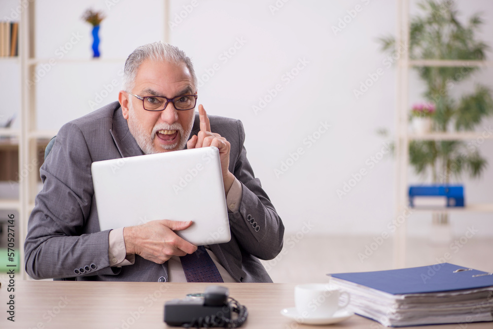 Old male employee working in the office Old male employee working in the office