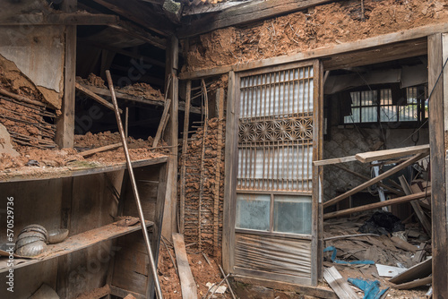 Urbex, destroyed room of an abandoned traditional South-Korean house, the walls, door and windows are broken, there are remains on the floor, the room is messy, dirty and dusty