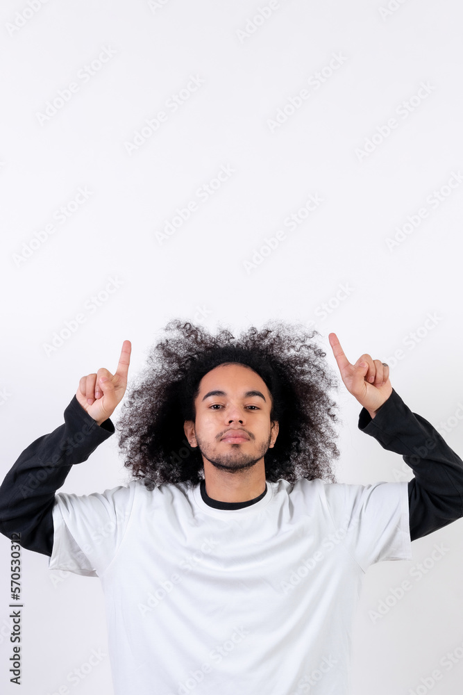 Pointing above a copy paste space. Young man with afro hair on white background Pointing above a copy paste space. Young man with afro hair on white background