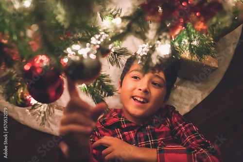 Boy under the Christmas Tree at night time