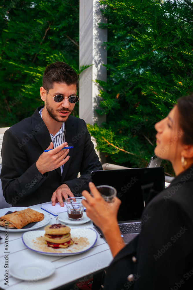 A businessman is explaining to his female partner A businessman is explaining to his female partner