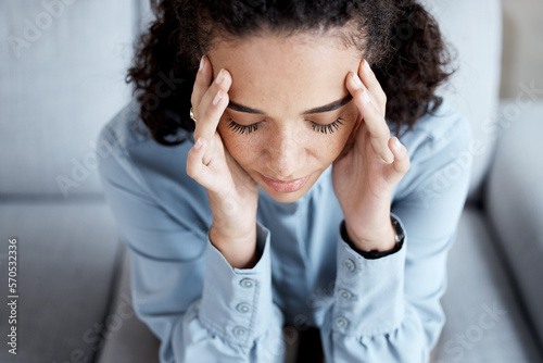 Stress, headache and woman at psychology for mental health, grief or depression counseling. Frustration, anxiety and sad stressed female patient sitting on sofa with migraine at psychotherapy session