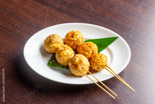Foto 香ばしく焼き上げた地鶏のつくねに、秘伝のタレが艶やかに絡み合う「つくねタレ」。しっとりした肉の質感が際立つ一景で、居酒屋の看板メニューやおつまみの販促に最適な高品質素材です。 | Grilled chicken meatballs glazed with savory tare sauce