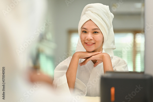 Serene young woman in bathrobe and towel on head relaxing after taking shower bath. Beauty treatment concept