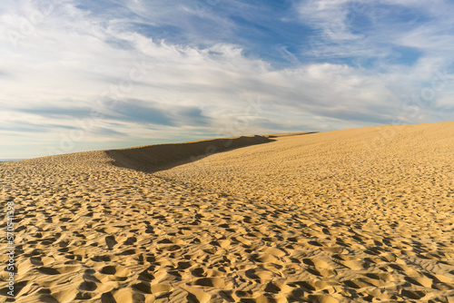 sand dunes in the desert with sky blue and clouds 