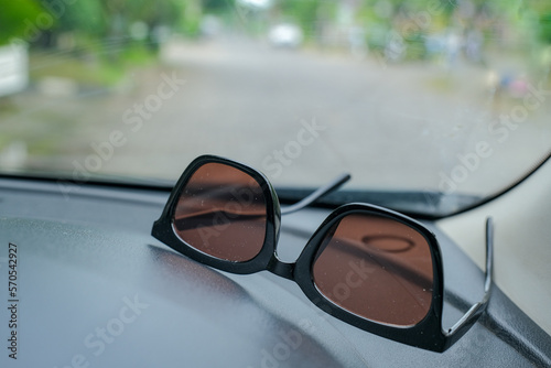 Sun glasses left on car dashboard under direct sunlight
