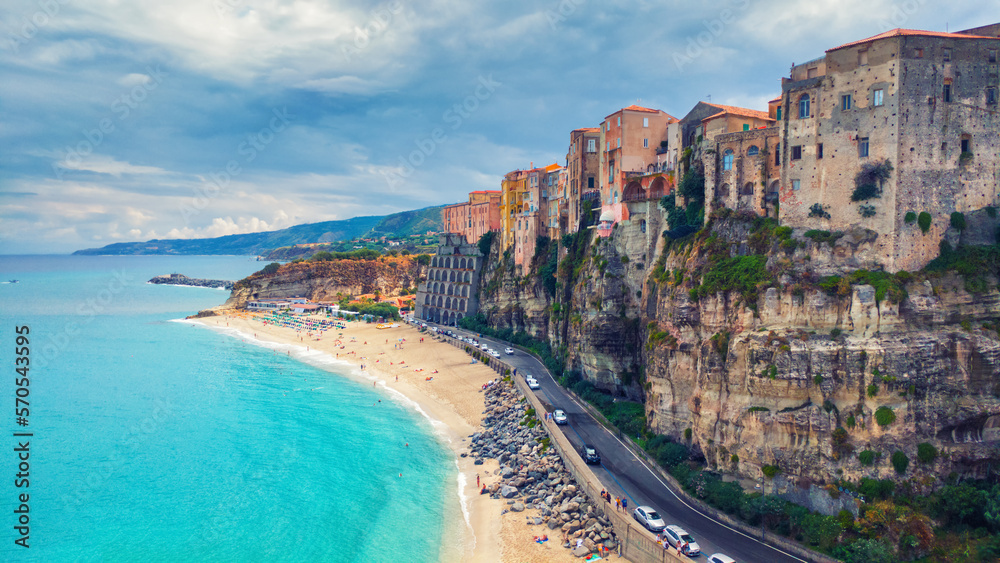 Landscape with Tropea beach and old town buildings on mountain rock in Italy.