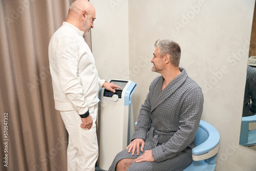 Gorgeous Caucasian specialist is consulting man in the health center