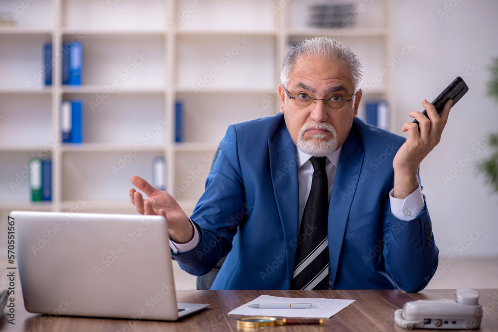 Old male employee working in the office Old male employee working in the office
