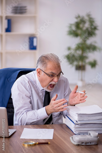 Old male employee working in the office