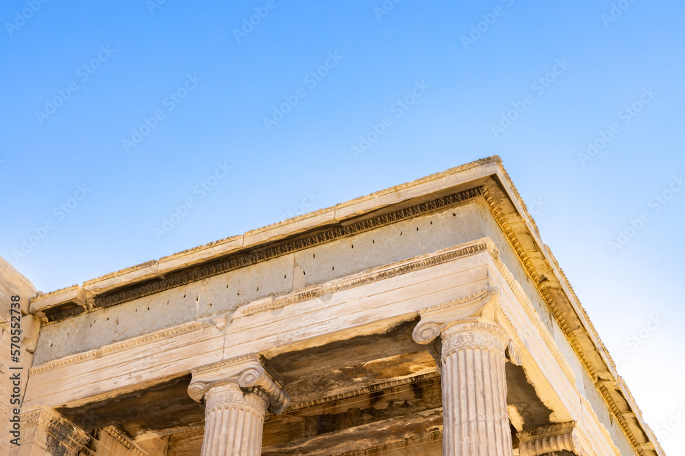 Sun hiding behind the columns of the Parthenon temple at Acropolis site on a sunny evening in Athens Greece