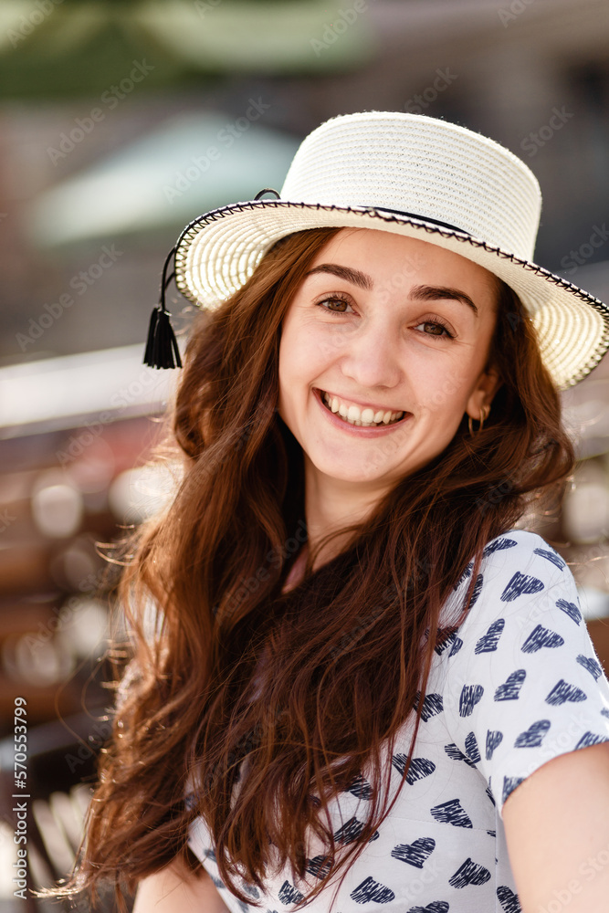 young happy woman in a dress and a hat