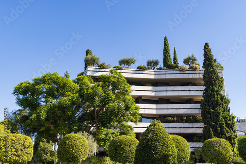 Canvas Print Modern appartment building with a green roof with trees in green surrounding in