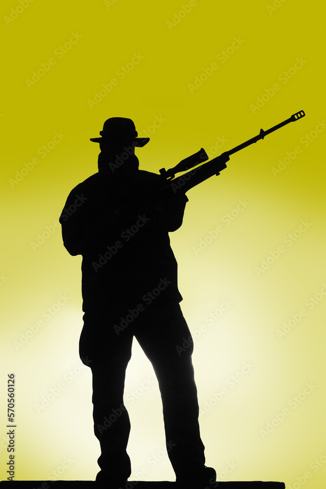 silhouette of a soldier a sniper in a hat with a rifle