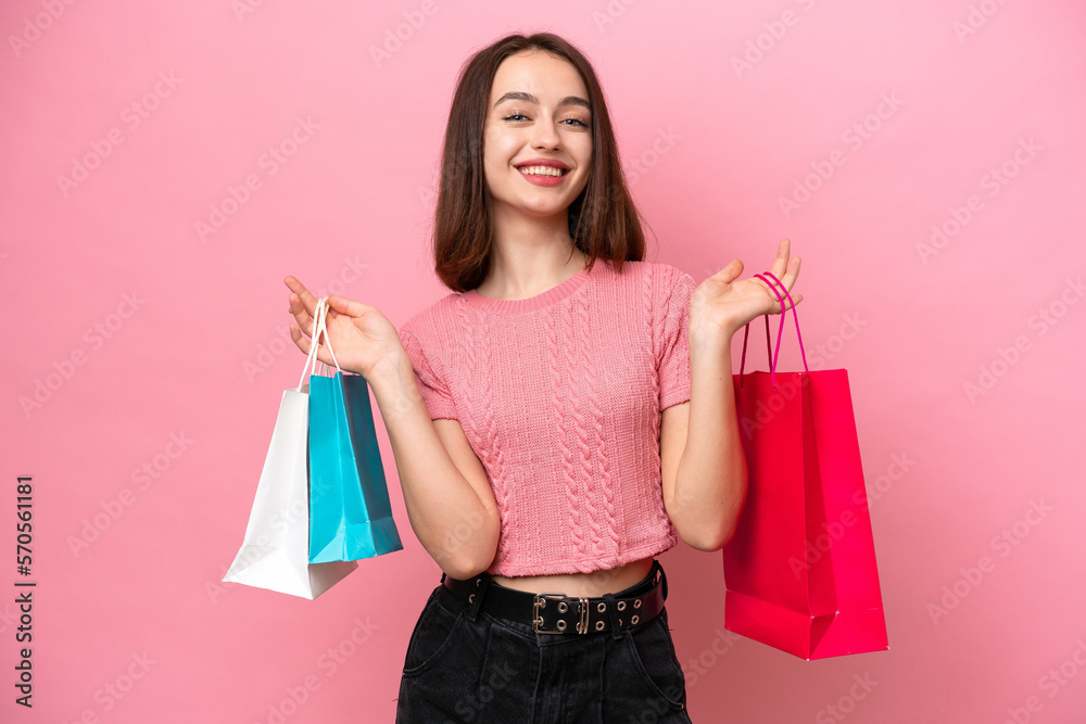 Young Ukrainian woman isolated on pink background holding shopping bags and smiling Young Ukrainian woman isolated on pink background holding shopping bags and smiling