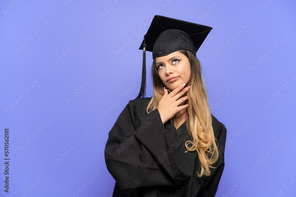 Young university graduate Russian girl isolated on white background looking up while smiling Young university graduate Russian girl isolated on white background looking up while smiling