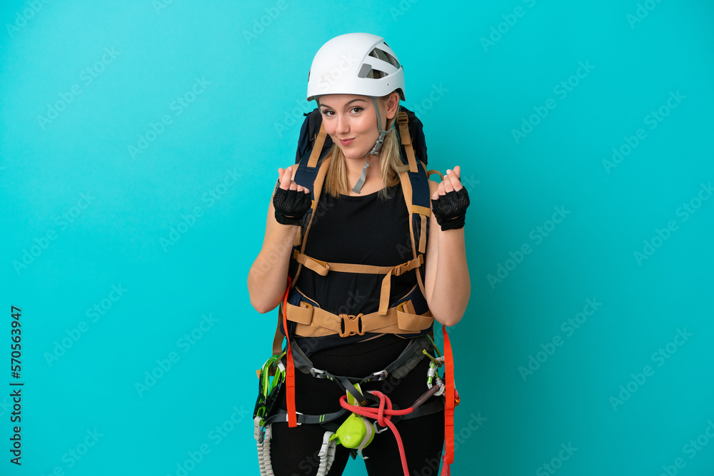 Young caucasian rock climber woman isolated on blue background making money gesture Young caucasian rock climber woman isolated on blue background making money gesture