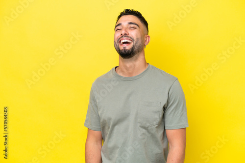 Young Arab handsome man isolated on yellow background laughing