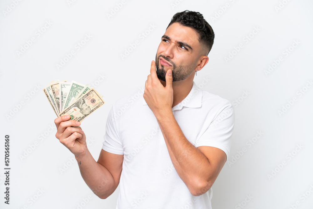 Young Arab man taking a lot of money isolated on white background having doubts Young Arab man taking a lot of money isolated on white background having doubts