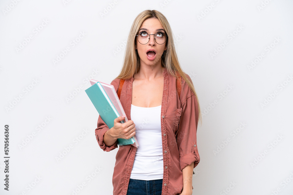 Pretty student blonde woman isolated on white background looking up and with surprised expression Pretty student blonde woman isolated on white background looking up and with surprised expression